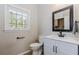 Modern bathroom featuring a vanity with marble countertop, black fixtures, and a large window at 1019 Walnut Creek Dr, Woodstock, GA 30188