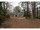 Spacious backyard with a view of the house and surrounding woods at 1472 Silver Maple Sw Ct, Lilburn, GA 30047