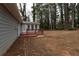 Home's backyard with wooden deck and sunroom, surrounded by trees at 1472 Silver Maple Sw Ct, Lilburn, GA 30047