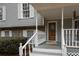 Classic front porch with white columns and wooden door at 1472 Silver Maple Sw Ct, Lilburn, GA 30047