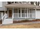 Charming front porch with white railings and a wooden door at 1472 Silver Maple Sw Ct, Lilburn, GA 30047