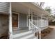 Home's front porch with white railings, steps, and a wooden door at 1472 Silver Maple Sw Ct, Lilburn, GA 30047