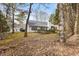 House backyard with wooded area and leaf covered ground at 306 Hickory Pointe Ct, Villa Rica, GA 30180