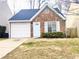 Brick house with a white garage door and manicured bushes at 1040 Hillsborough Chase Nw, Kennesaw, GA 30144