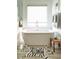 Free standing bathtub with window and stylish rug at 370 Park Ne Pl, Atlanta, GA 30317