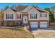 Two-story house with brick and beige siding, red shutters, and a two-car garage at 3525 W River Commons, Douglasville, GA 30135