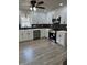 Modern kitchen with white cabinets, stainless steel appliances, and sleek black backsplash at 3967 Evelyn Dr, Powder Springs, GA 30127
