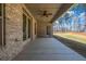 A covered back porch with outdoor fan looks out onto a partially wooded lawn at 125 Drummond Pl, Covington, GA 30014