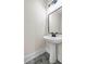 Bright powder room featuring a pedestal sink, hexagon tile floor and black hardware at 125 Drummond Pl, Covington, GA 30014