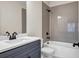 Modern bathroom with gray tile, a white vanity, and a shower-tub combo at 125 Drummond Pl, Covington, GA 30014