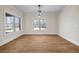 Bright dining room with hardwood floors, light fixtures, and large windows overlooking the front yard at 125 Drummond Pl, Covington, GA 30014