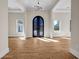 Elegant foyer featuring an ornate iron door, light hardwood flooring, and contemporary chandelier at 125 Drummond Pl, Covington, GA 30014