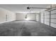 Spacious three car garage with concrete floors, white walls, and three garage doors at 125 Drummond Pl, Covington, GA 30014