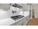 Close-up of the kitchen featuring white cabinets, a sleek stovetop, and a decorative backsplash at 125 Drummond Pl, Covington, GA 30014