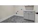 Laundry room featuring a utility sink, gray cabinet and hexagon tile floor at 125 Drummond Pl, Covington, GA 30014