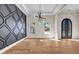 Open concept living area featuring hardwood floors, a decorative accent wall and wrought iron entry doors at 125 Drummond Pl, Covington, GA 30014