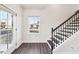 Inviting entryway featuring wood-look floors, natural light, and staircase with dark wood and white accents at 434 Herring Dr, Acworth, GA 30102