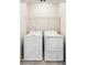Functional laundry area equipped with a washer, dryer, and overhead shelving for optimal storage at 434 Herring Dr, Acworth, GA 30102