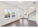 Living room featuring hardwood floors, large windows, and staircase with decorative spindles at 434 Herring Dr, Acworth, GA 30102