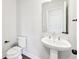 Modern powder room with a white pedestal sink, mirror, and black fixtures complementing the stylish interior design at 434 Herring Dr, Acworth, GA 30102