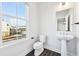 Bright powder room featuring a large window, modern fixtures, and a sleek pedestal sink at 434 Herring Dr, Acworth, GA 30102