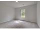 Neutral bedroom featuring natural light from one window and plush carpet at 157 Haverling Pass, Hampton, GA 30228