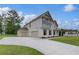 Side view of house, showcasing a three-car garage and ample parking space at 157 Haverling Pass, Hampton, GA 30228