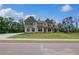 Beautiful two-story home featuring a manicured lawn and light-colored brick facade at 157 Haverling Pass, Hampton, GA 30228