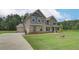 Lovely two-story home featuring attached garage, brick accents, and large lawn at 157 Haverling Pass, Hampton, GA 30228