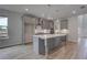 Modern gray kitchen with island and stainless appliances, featuring wood grain flooring at 157 Haverling Pass, Hampton, GA 30228