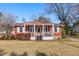 Inviting single-story home featuring a bright red exterior with shutters and a charming front porch at 318 Stewart Nw Ave, Marietta, GA 30064