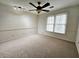 Neutral carpeted bedroom featuring a ceiling fan and large windows for natural light at 1409 Oakridge Cir, Decatur, GA 30033