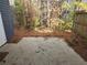 Backyard with concrete patio is bordered by a wood fence and a lush, wooded landscape at 926 Westland Dr, Marietta, GA 30064