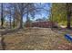 Large backyard view with mature trees surrounding the home's brick exterior at 5380 Saint Lo Ln, Atlanta, GA 30349