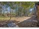 View of the backyard with mature trees, outbuilding, and partial view of the brick home at 5380 Saint Lo Ln, Atlanta, GA 30349