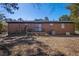 Spacious backyard view showcasing the exterior of the brick home with a mature tree line at 5380 Saint Lo Ln, Atlanta, GA 30349