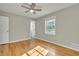 Bright bedroom features a ceiling fan, gleaming hardwood floors, and ample natural light from the window at 5380 Saint Lo Ln, Atlanta, GA 30349