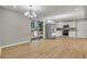 Open-concept dining area with chandelier and views of the kitchen and living areas with light wood floor at 5380 Saint Lo Ln, Atlanta, GA 30349