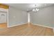 Open-concept dining area with chandelier and opening to bright living room with light wood floor at 5380 Saint Lo Ln, Atlanta, GA 30349