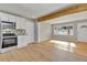 Modern kitchen with stainless steel appliances, white cabinets, opening to bright living room with light wood floor at 5380 Saint Lo Ln, Atlanta, GA 30349