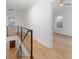 Upstairs hallway with modern railing leading to a bedroom with wood floors at 1835 W Taylor Ave, East Point, GA 30344