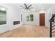 Light-filled living area with wood floors, fireplace, and modern staircase and trim at 1835 W Taylor Ave, East Point, GA 30344