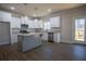 Bright, open kitchen featuring white cabinets, gray granite countertops, stainless appliances, and hardwood floors at 101 Azalea Dr, Villa Rica, GA 30180