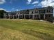 New two-story townhomes featuring brick accents, gray siding, multiple windows and a well-manicured lawn at 989 Cades Walk, Lawrenceville, GA 30045