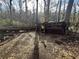 Exterior shot of wooded backyard with fallen tree, debris, and run-down wooden shed at 202 Hayes St, Villa Rica, GA 30180
