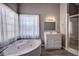 Bright bathroom features a corner soaking tub next to a window, and white vanity at 3634 Autumn Ridge Pkwy, Marietta, GA 30066