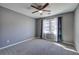 A carpeted bedroom with a ceiling fan and double-hung windows featuring blue patterned curtains at 3634 Autumn Ridge Pkwy, Marietta, GA 30066