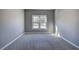 Light-filled bedroom featuring gray walls, white trim, carpet, and double hung windows overlooking the neighborhood at 3634 Autumn Ridge Pkwy, Marietta, GA 30066