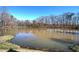 Still pond with a blue sky reflection surrounded by verdant trees and natural foliage on a sunny day at 3634 Autumn Ridge Pkwy, Marietta, GA 30066