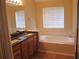 Bright bathroom with a large soaking tub, double vanity, and window at 959 Romer Pl, Stone Mountain, GA 30083